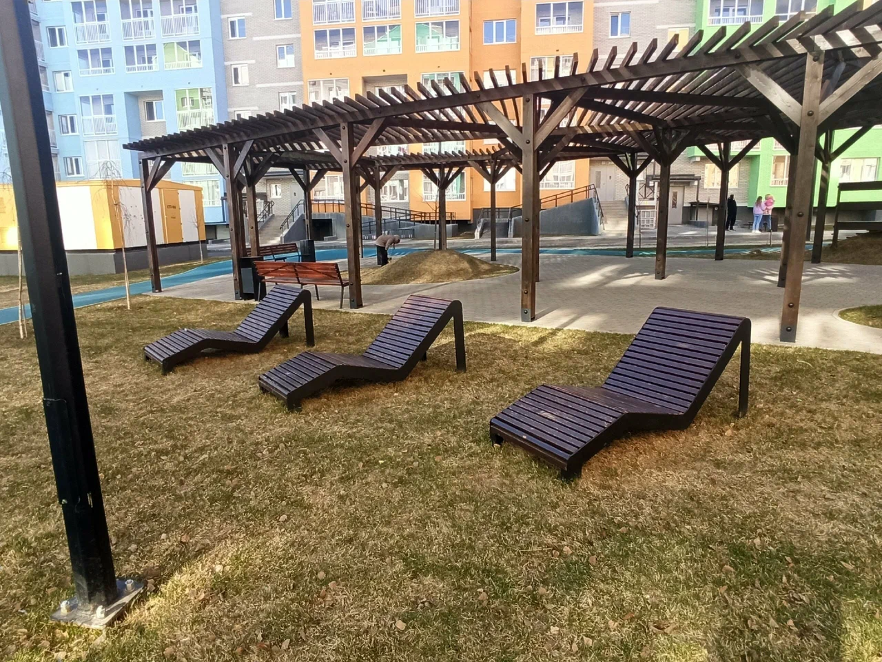 Парковые лежаки и перголы на территории жилого комплекса